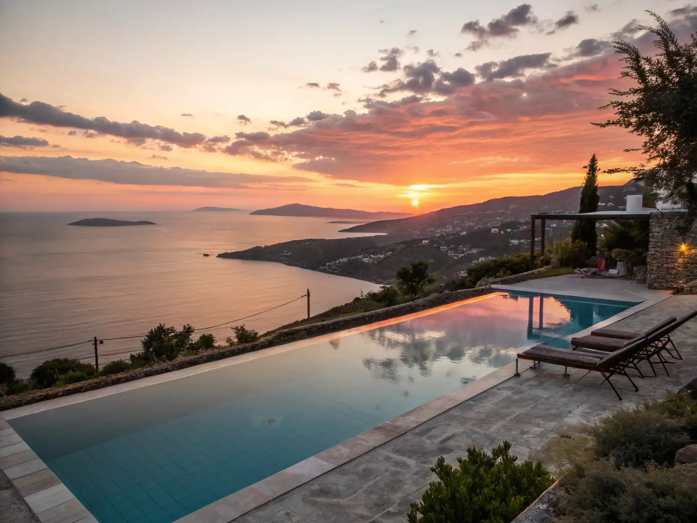 A photograph of a guest relaxing by the infinity pool at Casa Vella, with a clear view of the sea and Dalt Vila in the background.